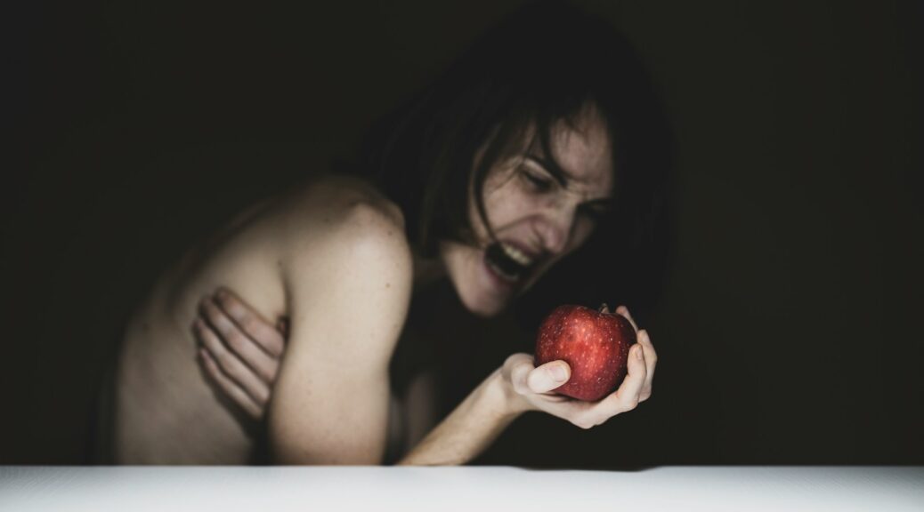 topless woman holding red apple